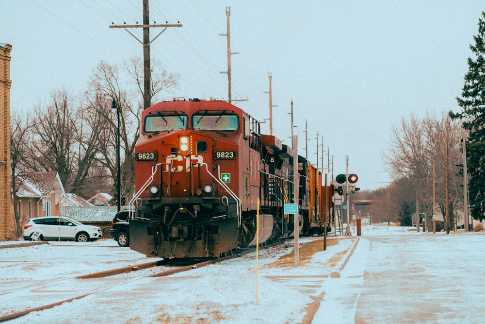 A train rolling along tracks during the winter.
